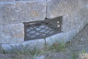 A hole in the ground with a metal grate.